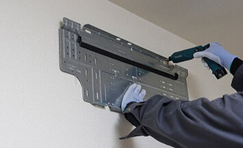 据付板を壁に取り付ける様子